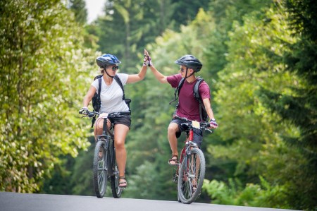 two people high five in a cycling trail