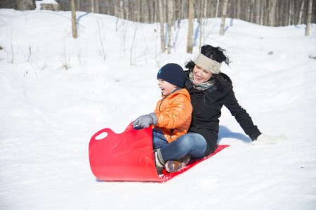 a kid sledding with his mother