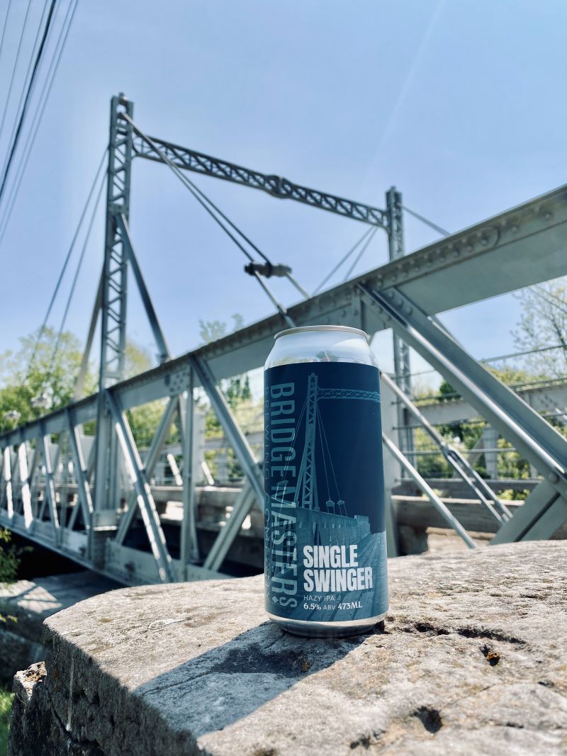 a can of beer in front of a bridge