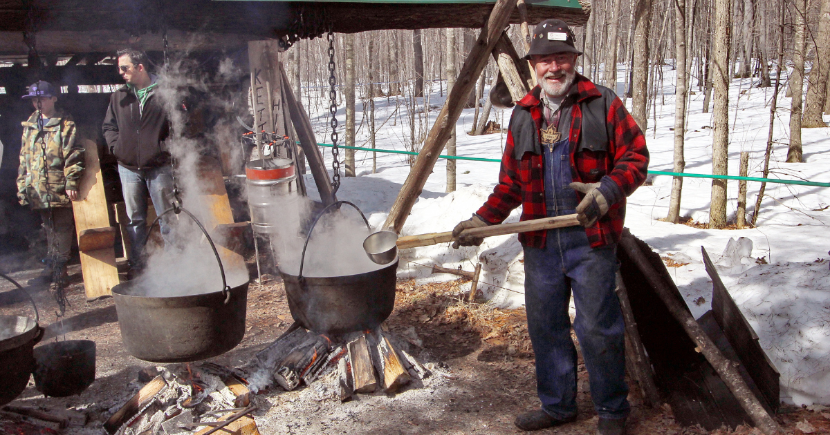 a man boiling maple syrup in a large pot